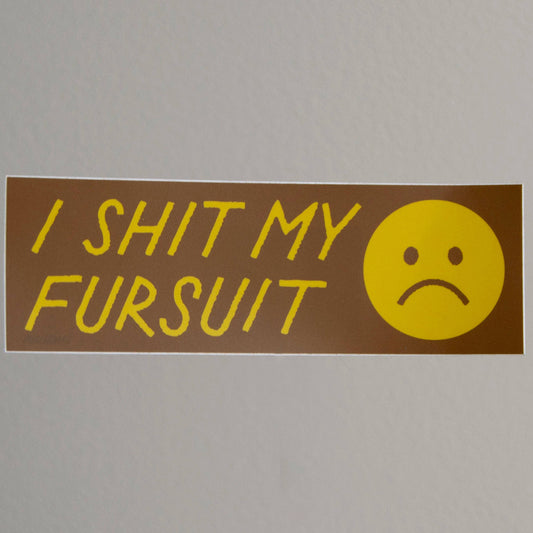 Sticker with text 'I SHIT MY FURSUIT' and a sad face on a gray background