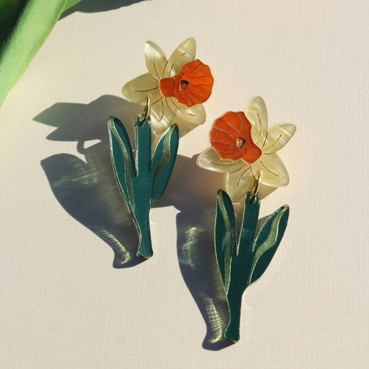 Floral earrings with orange and white flowers on a light background