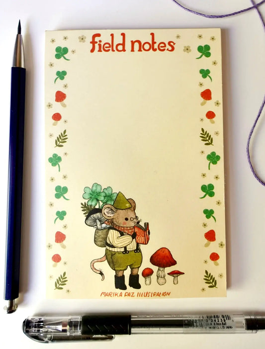 Field Notes notebook with a mouse illustration and decorative border, accompanied by two pens.