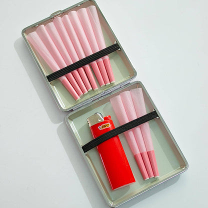 Pink cigarettes in a metal case with a red lighter on a white background