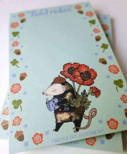 Notebook with illustration of a mouse holding flowers on a light blue background with floral patterns