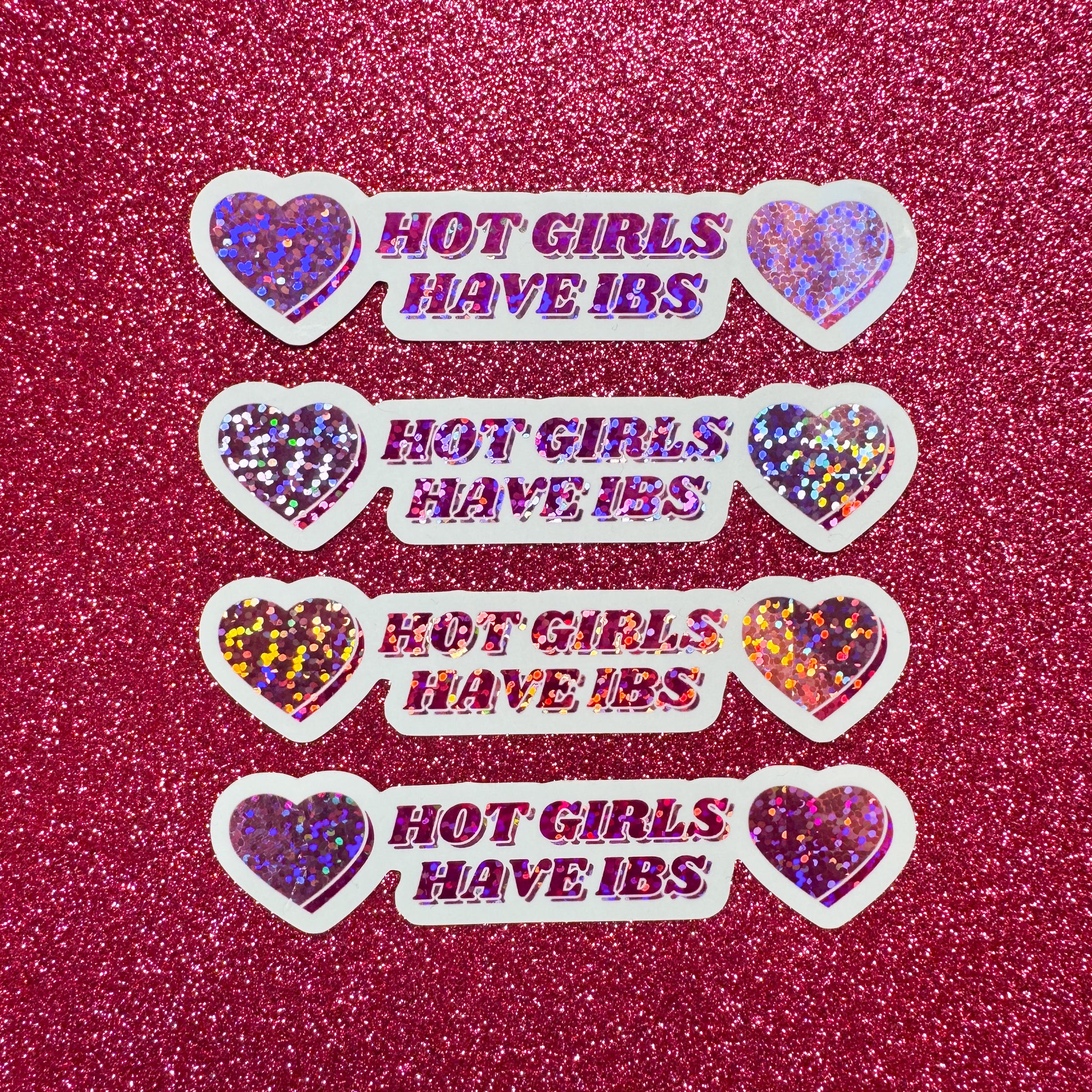 Glittery 'Hot Girls Have IBS' stickers on a pink glitter background