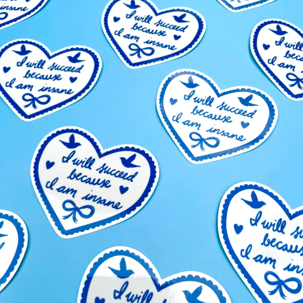 Heart-shaped stickers with motivational text on a blue background