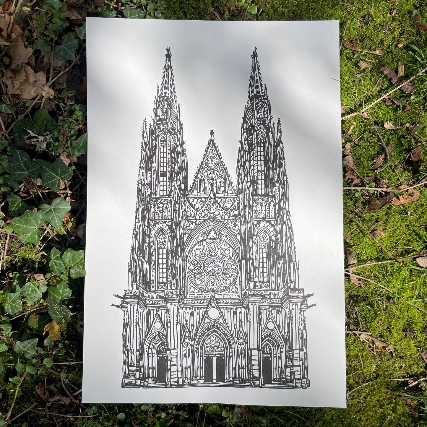 Gothic cathedral illustration on a white sheet of paper lying on green grass.