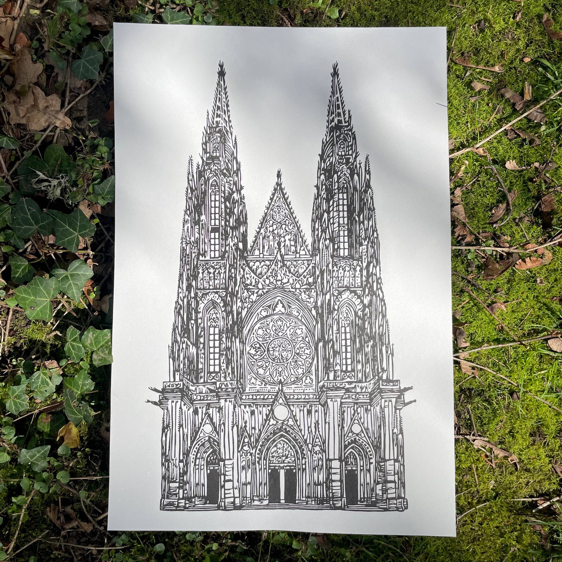 Gothic cathedral illustration on a white sheet of paper lying on green grass.
