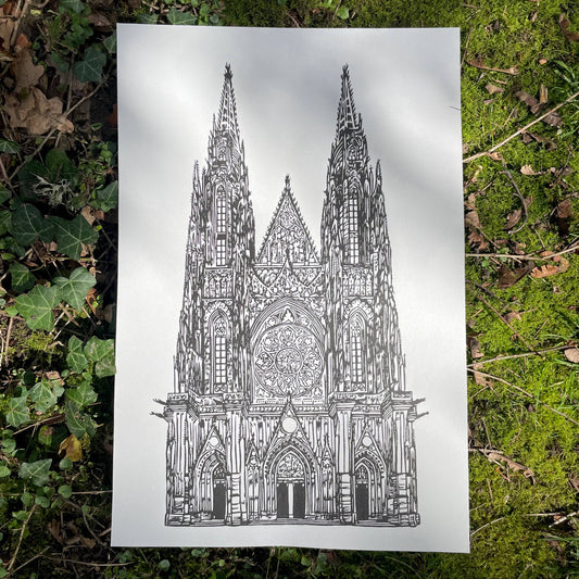 Gothic cathedral illustration on a white sheet of paper lying on green grass.