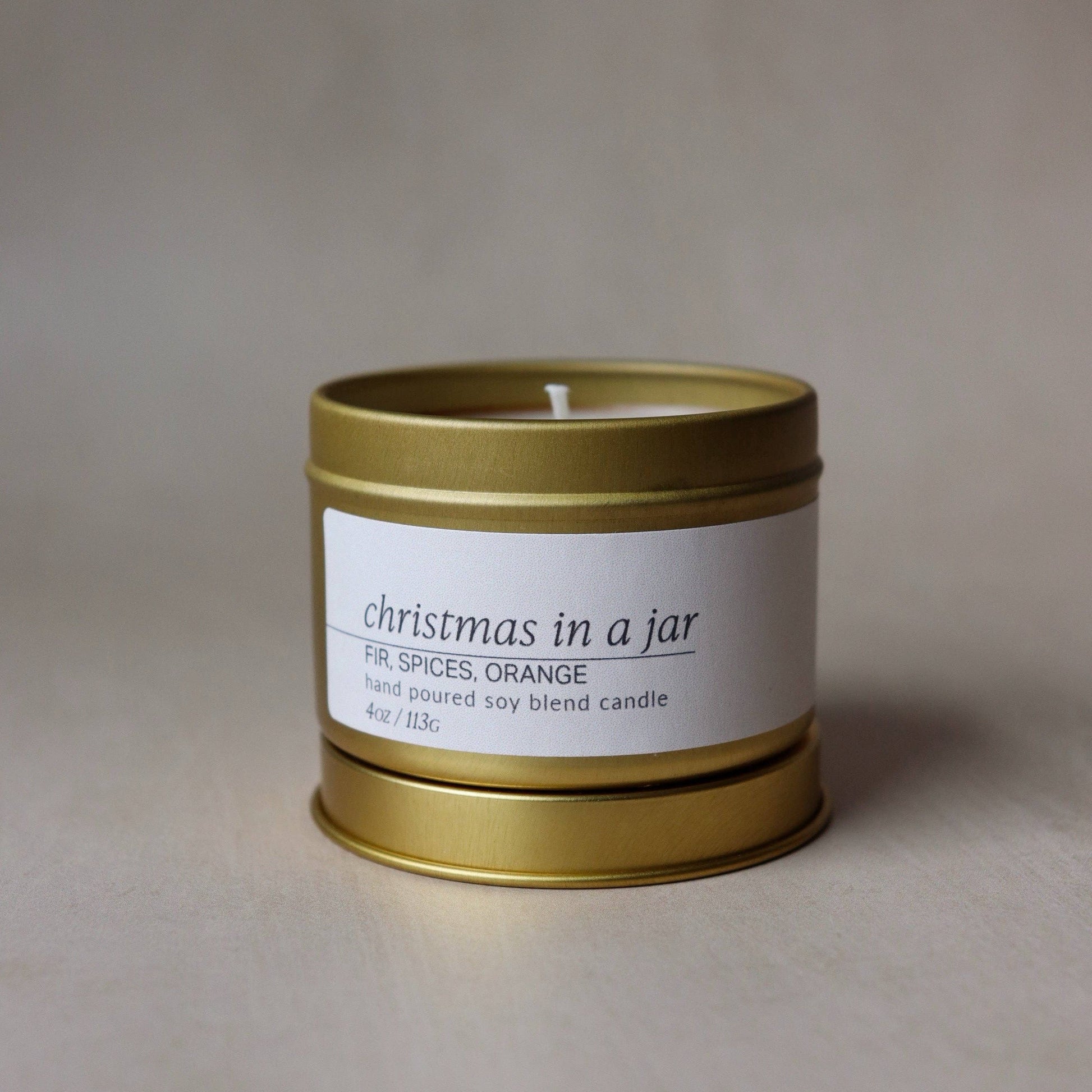 Gold candle jar with a white label on a beige background