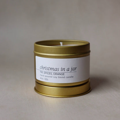 Gold candle jar with a white label on a beige background