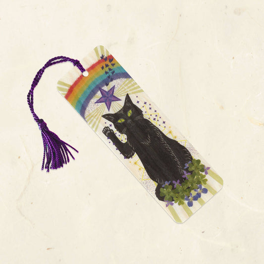 Bookmark with a black cat, rainbow, and star design on a beige background