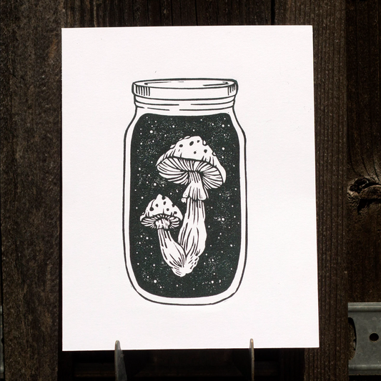Linocut print of mushrooms inside a mason jar on a white background