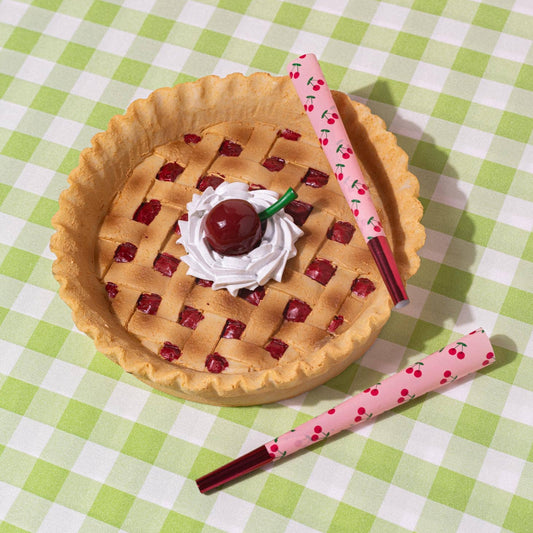 Pie-shaped ashtray with cherry and whipped cream on a green checkered tablecloth