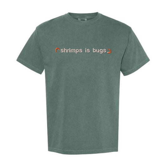 Green t-shirt with text 'shrimps is bugs' on a white background